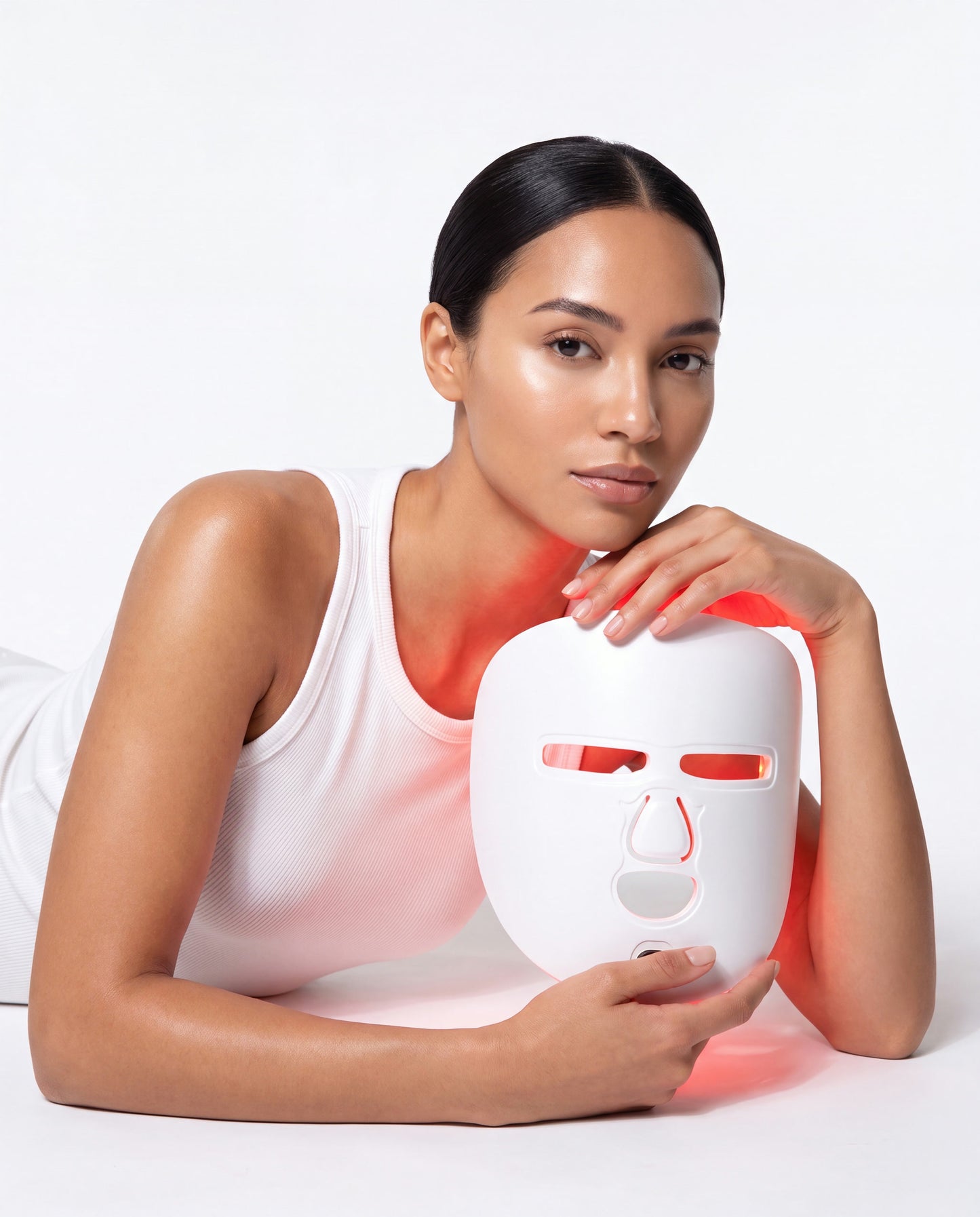 Lumière LED light therapy mask held by model in studio